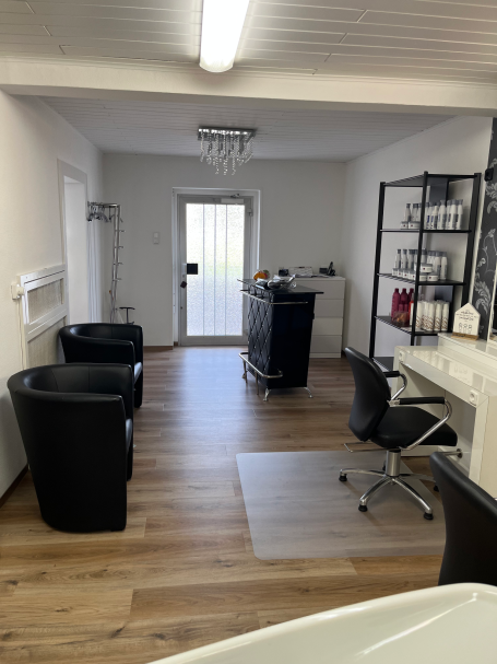 Der Eingangsbereich des Salons mit einer Theke und zwei Sesseln